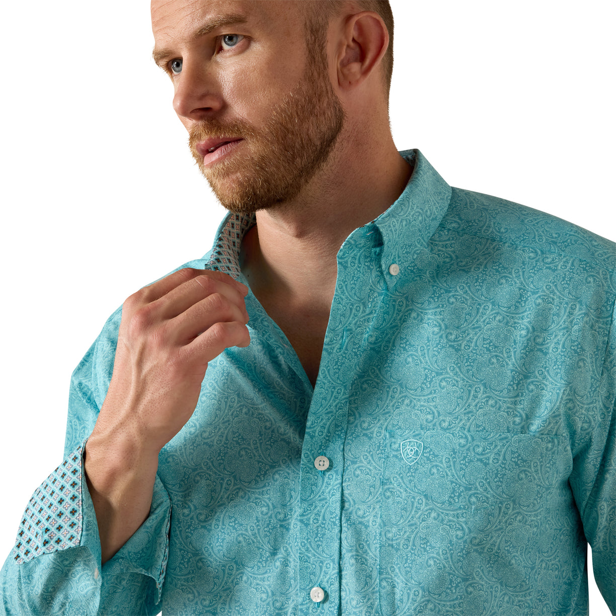 Man wearing a teal patterned shirt against a white background