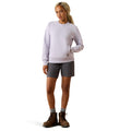 Person wearing a white sweatshirt, gray shorts, and brown boots on a white background