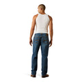 Man wearing a white tank top and blue jeans on a white background