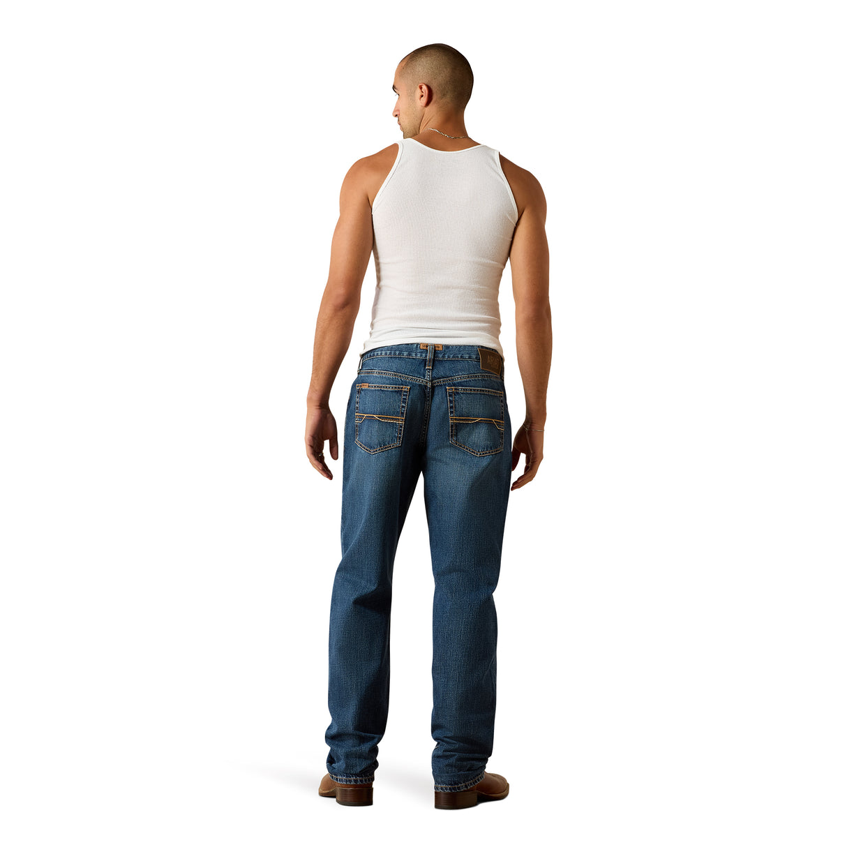 Man wearing a white tank top and blue jeans on a white background