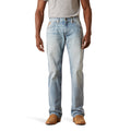 Person wearing light blue jeans and brown shoes on a white background