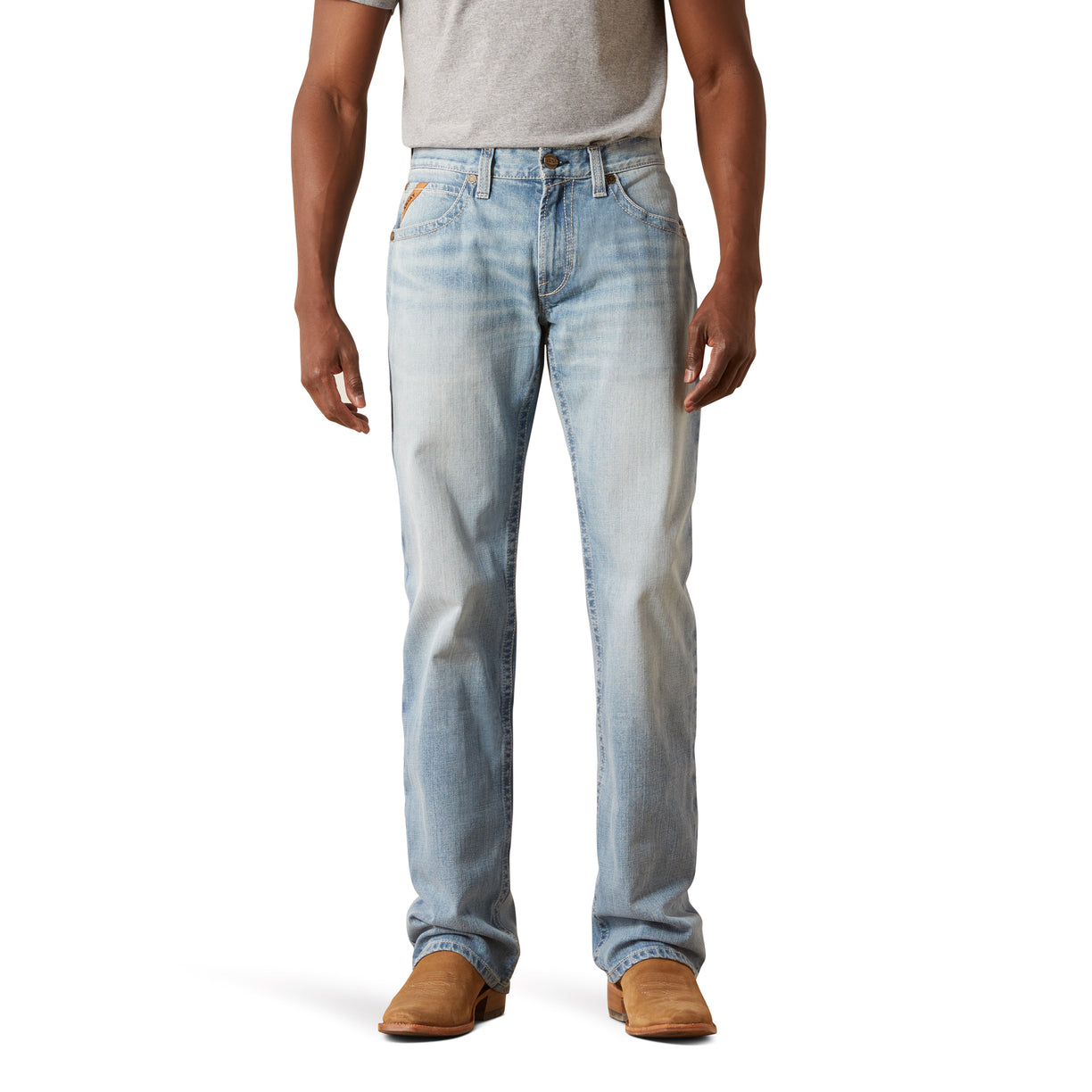 Person wearing light blue jeans and brown shoes on a white background