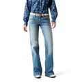 Person wearing blue jeans and a patterned shirt on a white background