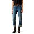 Person wearing blue jeans and black boots on a white background