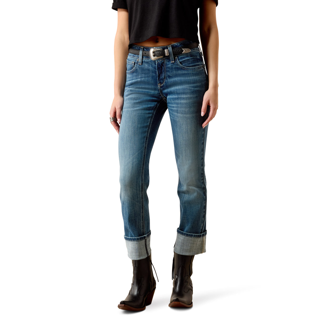 Person wearing blue jeans and black boots on a white background