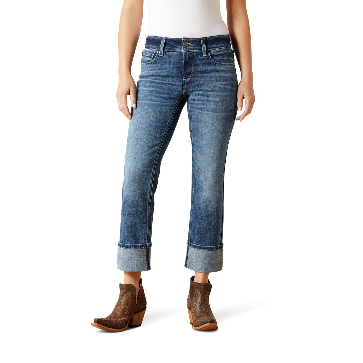 Person wearing blue jeans and brown boots on a white background