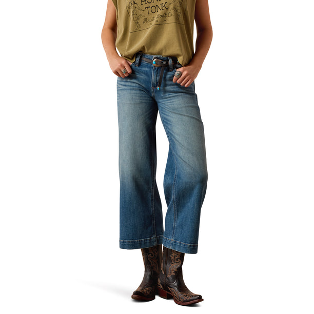 Person wearing blue jeans and cowboy boots on a white background