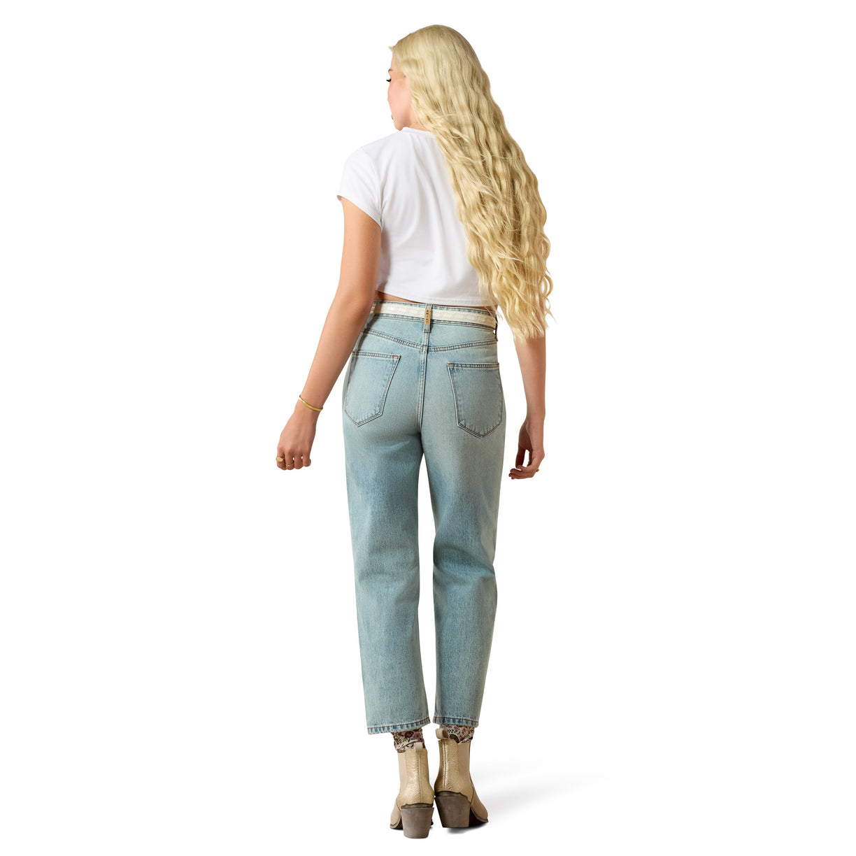 Woman wearing light blue jeans and a white top on a white background