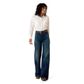Woman wearing a white shirt and blue jeans on a white background