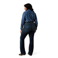 Person wearing a blue patterned shirt and dark jeans on a white background