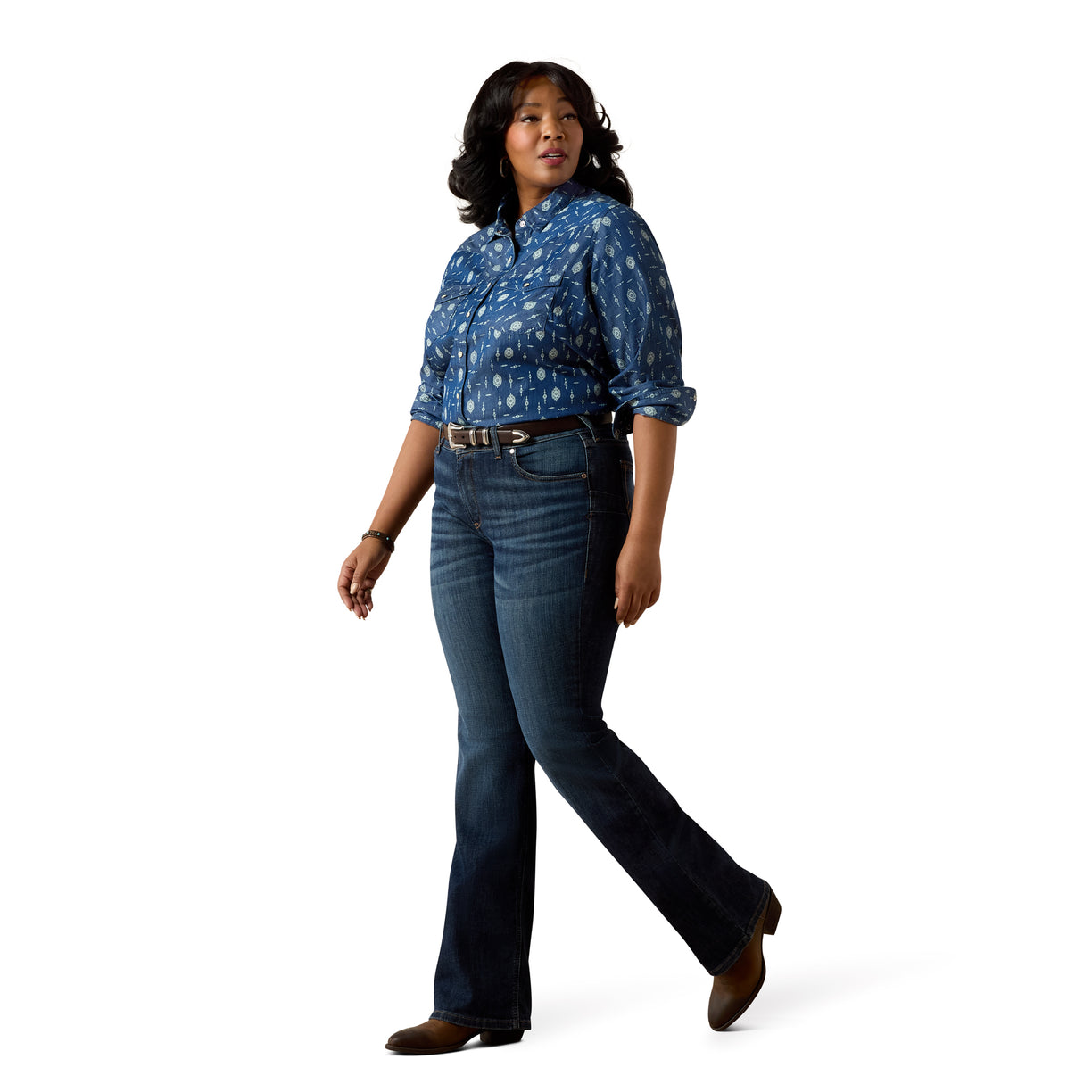 Woman wearing a blue patterned blouse and jeans on a white background