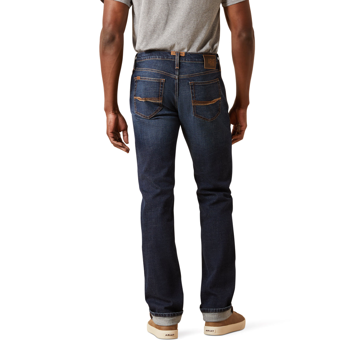 Person wearing dark blue jeans on a white background