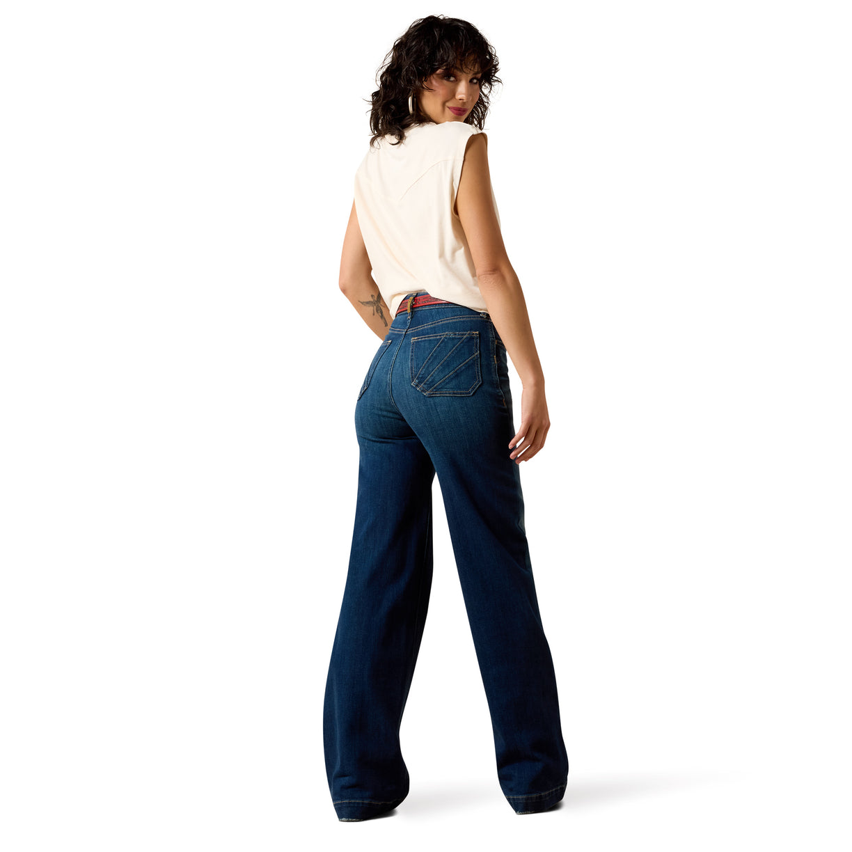 Woman wearing blue jeans and a white top on a white background