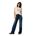 Woman wearing a white sleeveless shirt with a graphic design and blue jeans on a white background