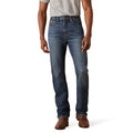 Person wearing blue jeans and brown shoes on a white background