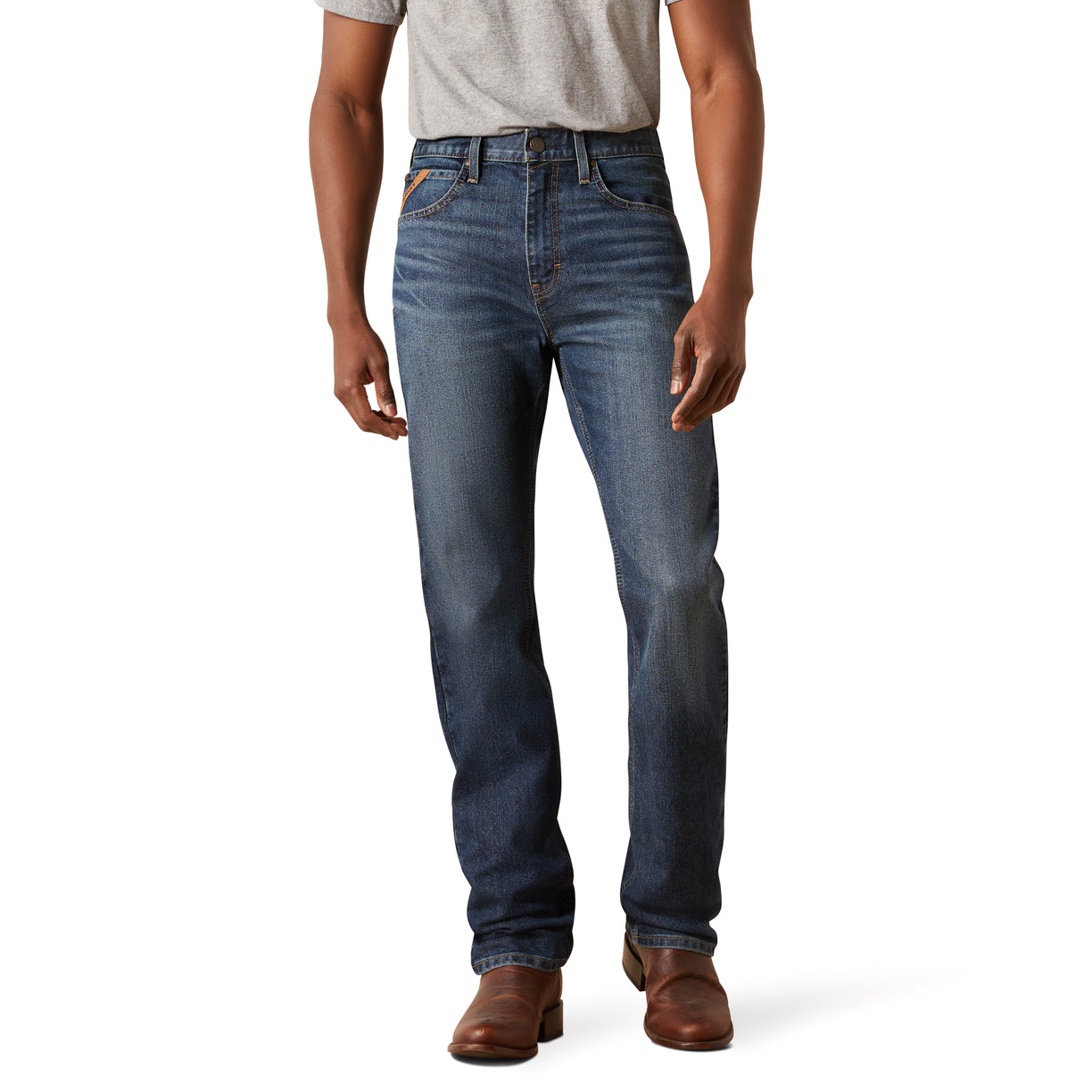Person wearing blue jeans and brown shoes on a white background