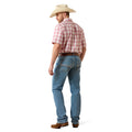 Man wearing a red plaid shirt, blue jeans, and a beige cowboy hat on a white background