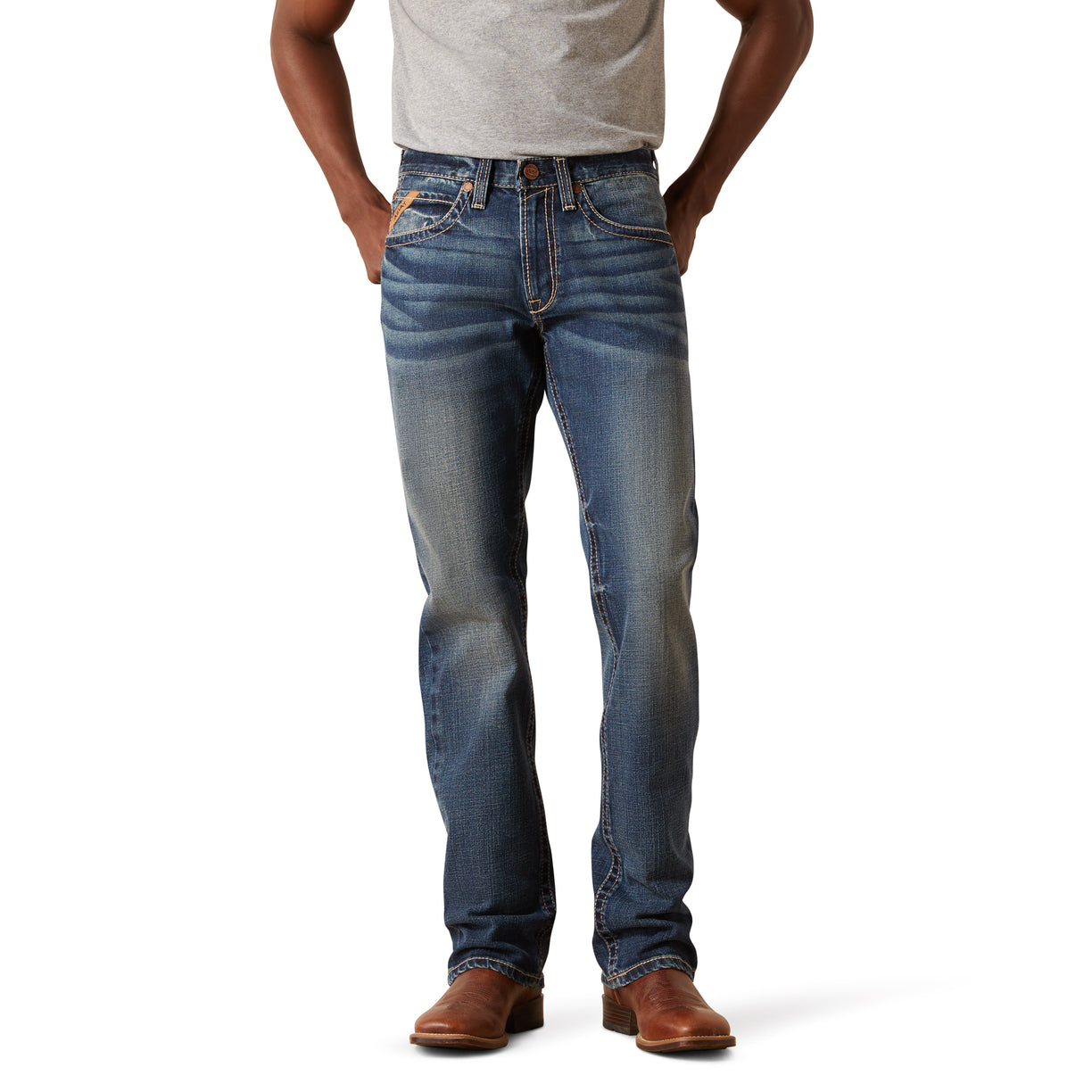 Person wearing blue jeans and brown shoes on a white background