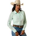 A woman modeling a light mint green long-sleeve western shirt with embroidered details on the sleeves, paired with a straw cowboy hat, brown belt, and blue jeans against a white background.