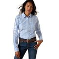 Woman wearing a light blue striped shirt with 'Ariat' branding on a white background