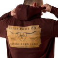 Brown hoodie with Ariat Boot Co. logo on the back against a white background