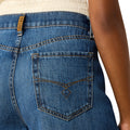Close-up of blue jeans with a brand label on a white background