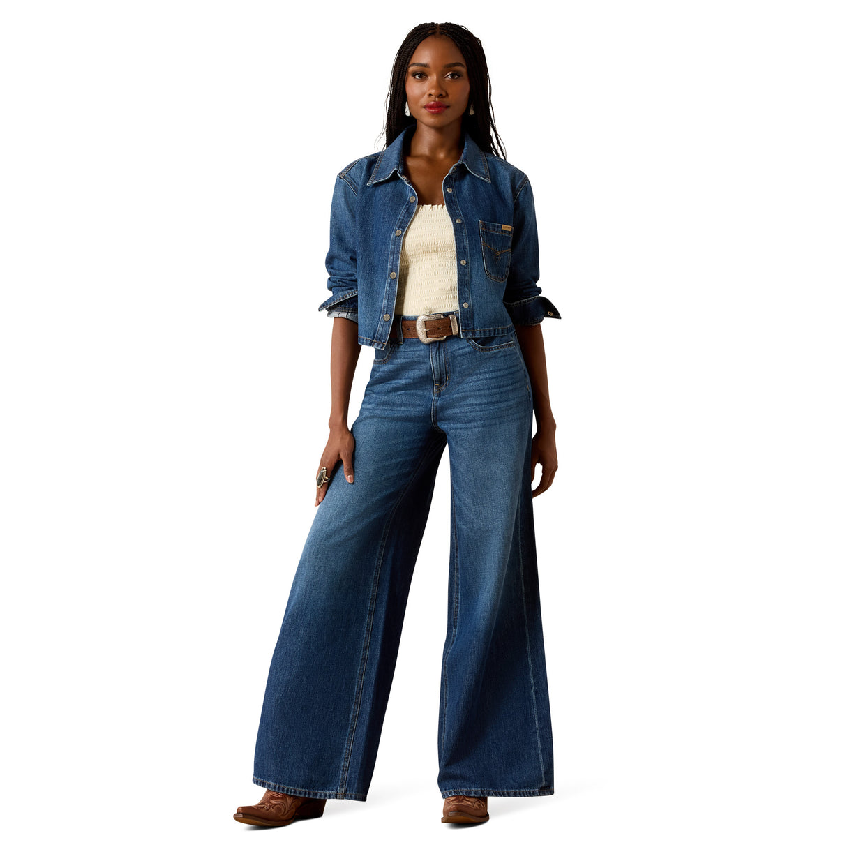 Woman wearing a denim jacket and wide-leg jeans on a white background