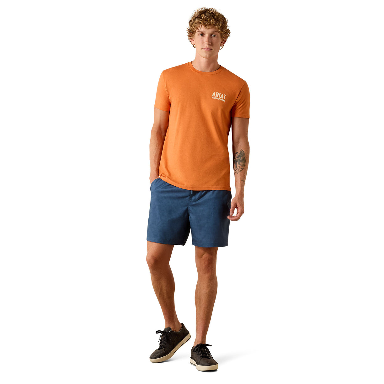 Man wearing an orange t-shirt and blue shorts on a white background