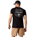 Man wearing a black Ariat t-shirt with a logo on the back, standing against a white background.