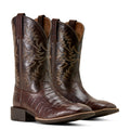 Pair of brown leather cowboy boots with intricate designs on a light background