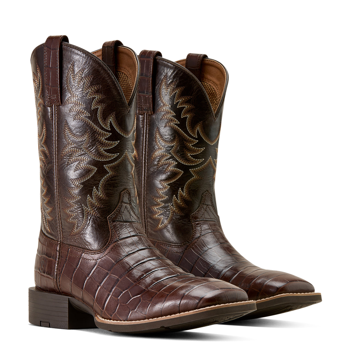 Pair of brown leather cowboy boots with intricate designs on a light background