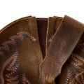 Close-up of brown leather boot with intricate stitching on a white background