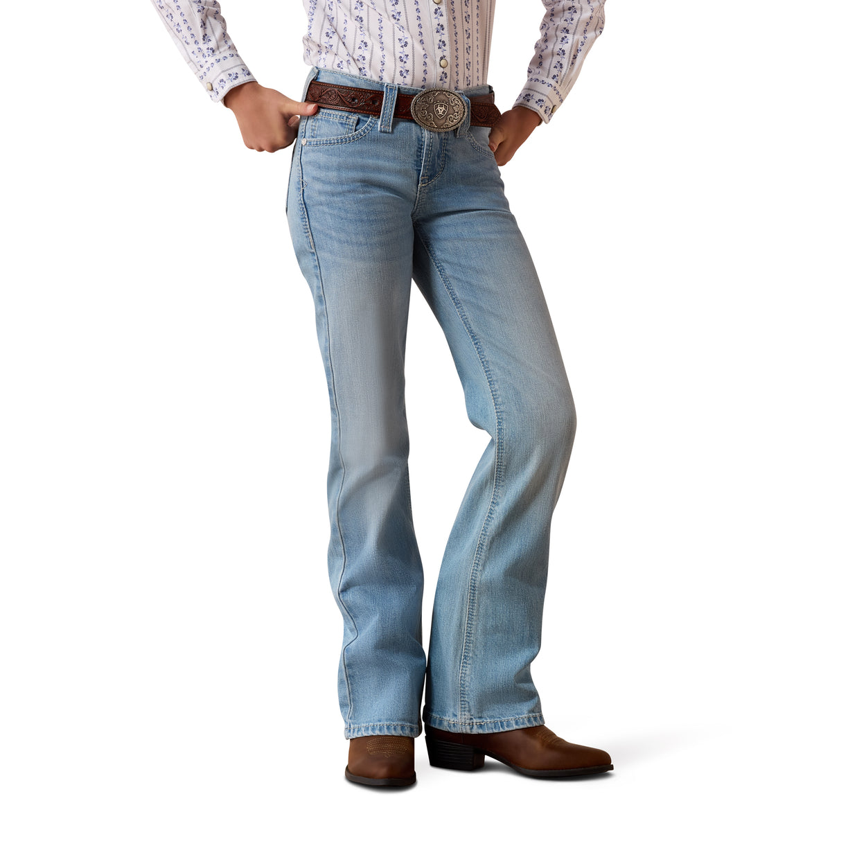 Person wearing light blue Ariat denim jeans and brown boots 
