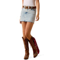 Woman wearing a pale blue Ariat denim skirt and cowboy boots