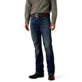Cowboy wearing blue Ariat straight leg jeans and a green shirt on a white background