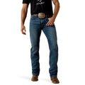 Man wearing blue Ariat Western jeans with a belt and brown boots on a white background