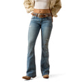Woman wearing Ariat blue flare jeans with a belt on a white background