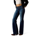 Blue Ariat boot cut jeans worn by a model with denim jacket on a white background