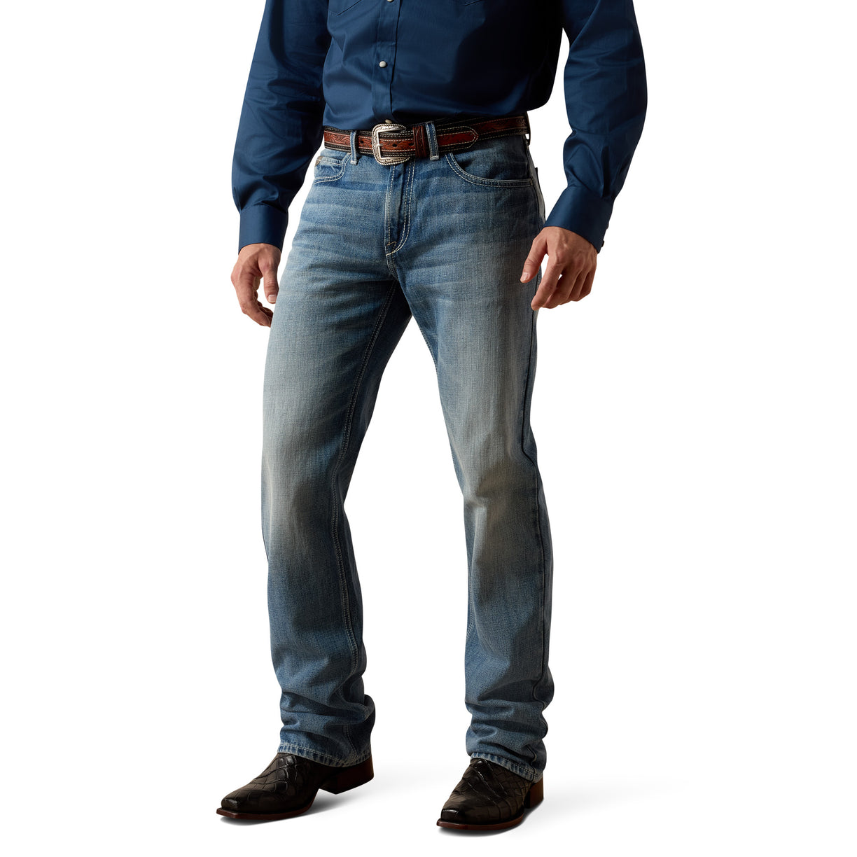 Person wearing blue boot cut Ariat jeans and a dark shirt on a white background