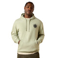 Man wearing a beige hoodie with a logo on a white background