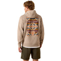 Person wearing a beige hoodie with a colorful back design and 'Ariat' branding on a white background