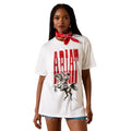 A woman modeling a white short-sleeve graphic T-shirt with a large red 'ARIAN' text print and a black western rider illustration on the front, paired with a red bandana and denim shorts against a white background.