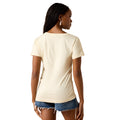 A woman shown from the back wearing a short-sleeve cream-colored t-shirt and denim shorts against a plain white background.