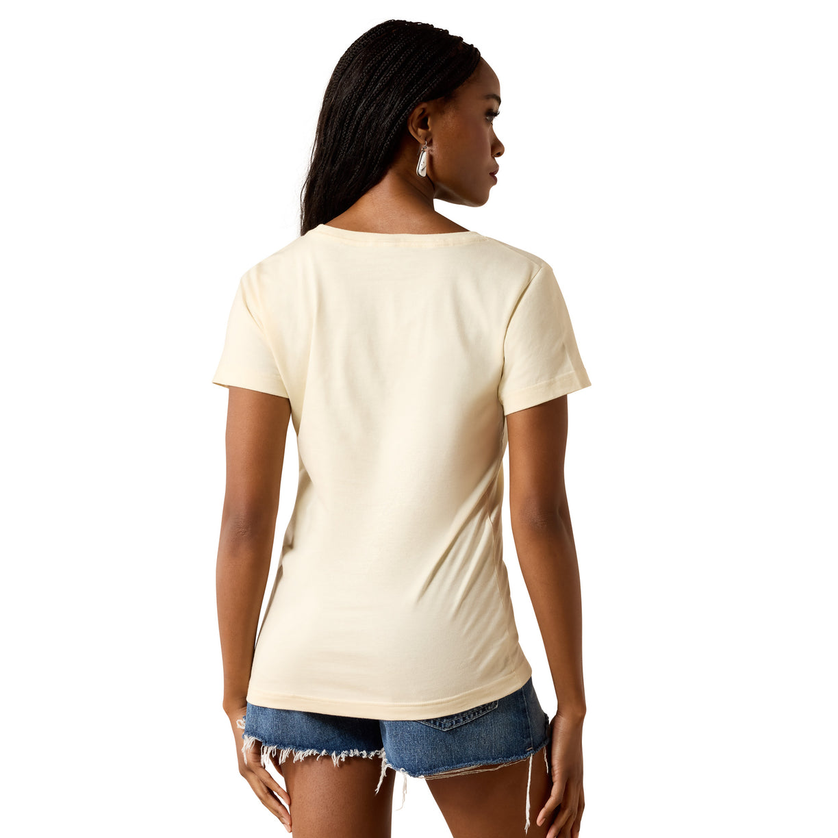 A woman shown from the back wearing a short-sleeve cream-colored t-shirt and denim shorts against a plain white background.
