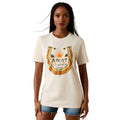 A woman modeling a cream-colored short-sleeve t-shirt with a large graphic on the front. The graphic features a golden-orange horseshoe with the word 'ARIAT' and printed inside.