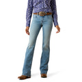 Woman wearing blue western jeans and a patterned shirt on a white background