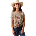 A young girl wearing a beige graphic t-shirt with a desert-themed print, blue jeans, and a cream cowboy hat
