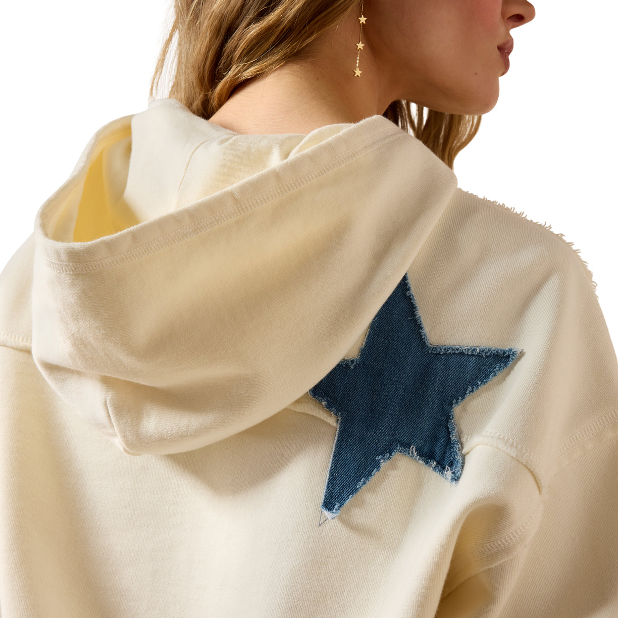 Beige hoodie with a blue star patch on a white background