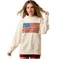 Woman wearing a cream hoodie with an American flag design on a white background