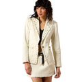 Woman wearing a white jacket with decorative buttons on a white background